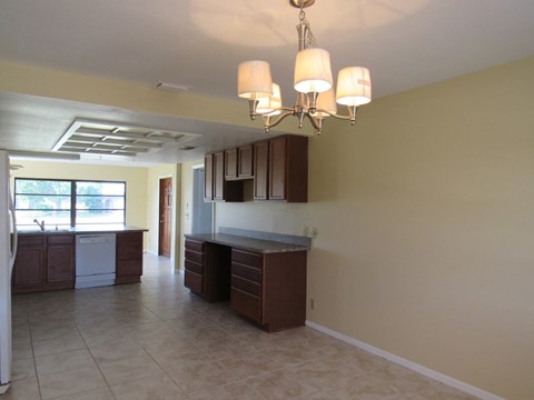 A kitchen with brown cabinets and a tiled floor.