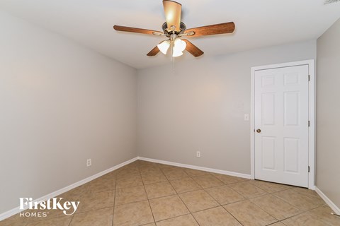the living room has a ceiling fan and a tiled floor