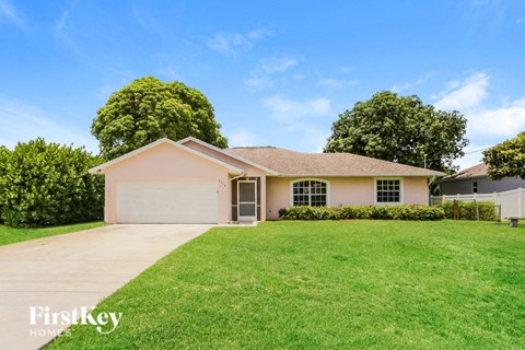 a beige house with a lawn in front of it