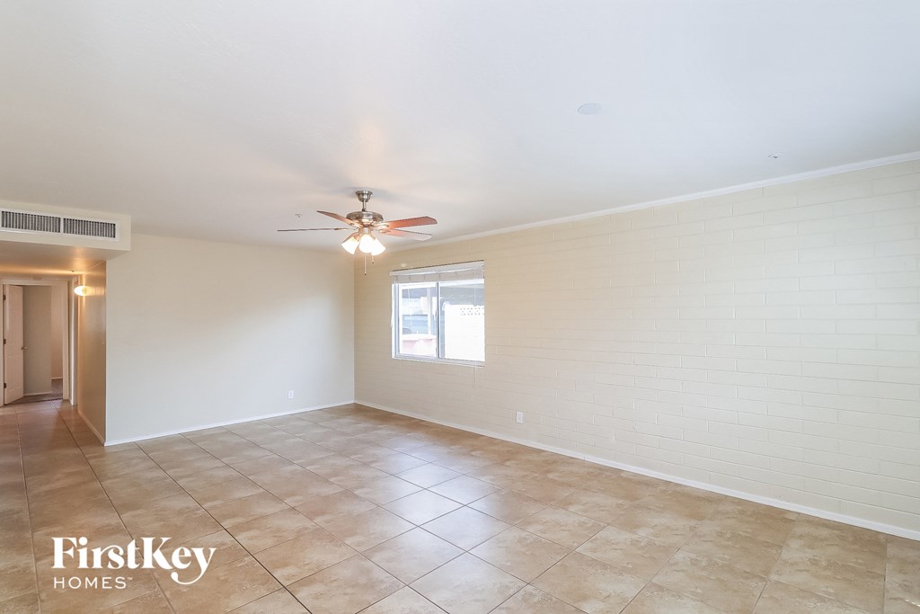 a living room with tile flooring and a ceiling fan