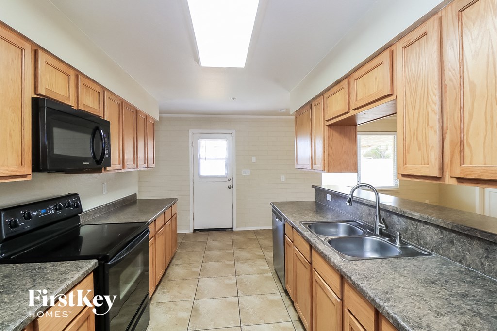 a kitchen with wood cabinets and granite counter tops and a sink
