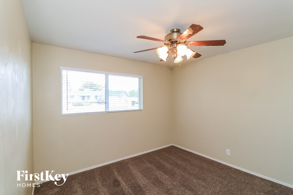 a bedroom with a ceiling fan and a window