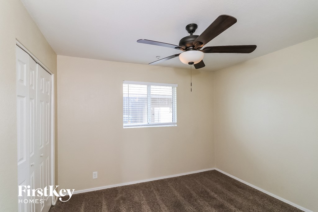 a bedroom with a ceiling fan and a window