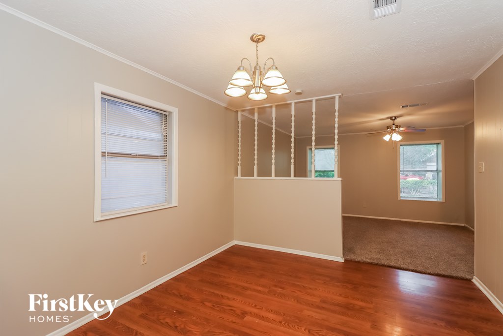 A room with wooden floors and a hanging light fixture.