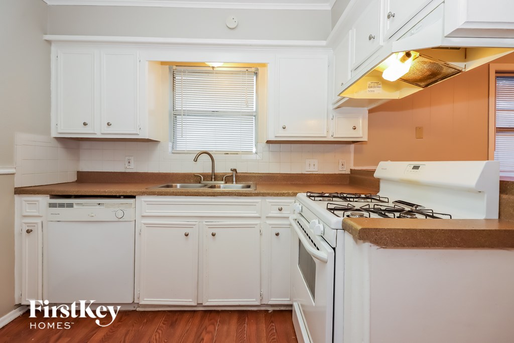 A kitchen with white cabinets and appliances.
