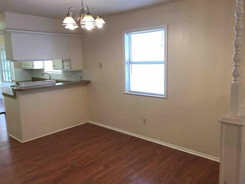 A kitchen with white cabinets and a window.