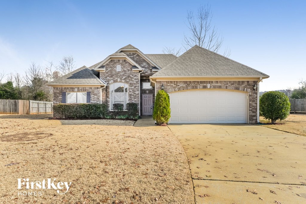a brick house with a garage and a driveway