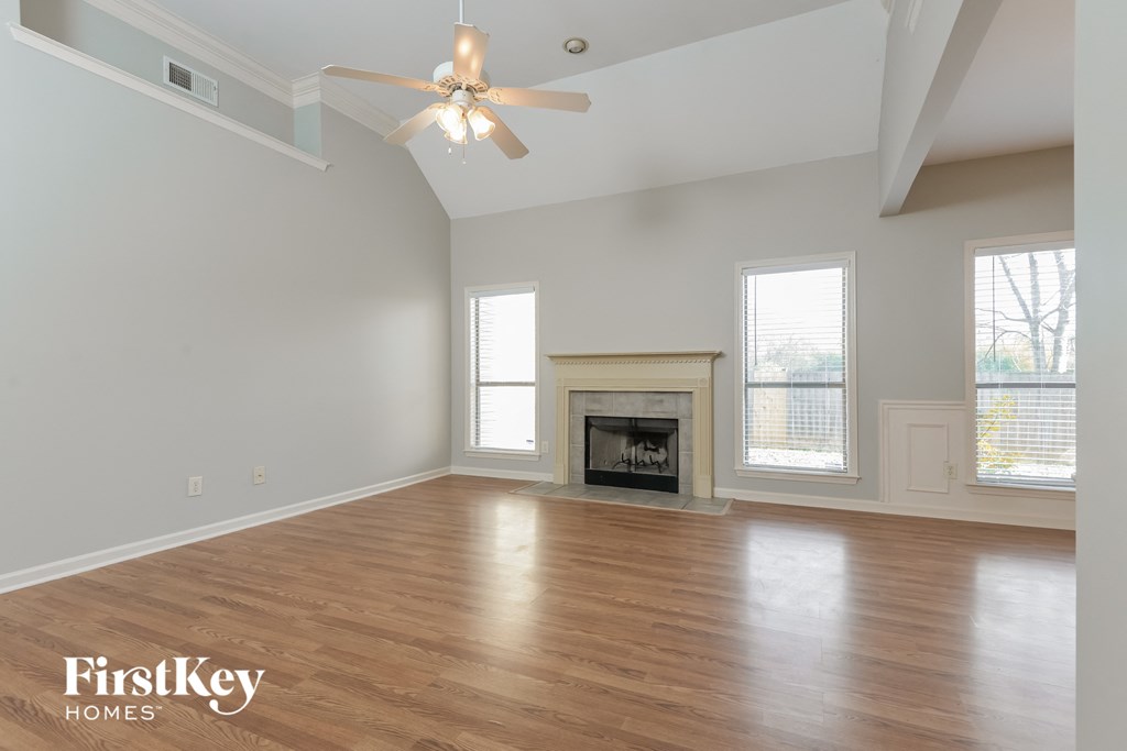 a living room with a fireplace and a ceiling fan