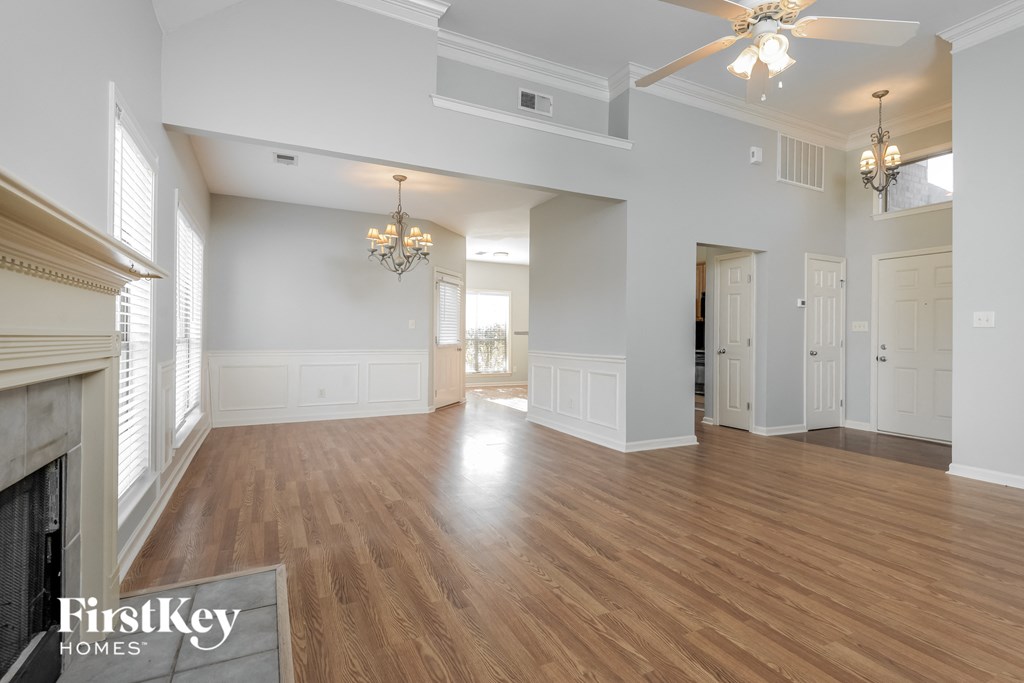 the living room and dining room with a fireplace and wood flooring