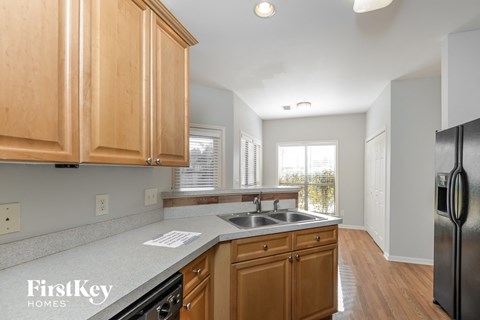 a kitchen with wooden cabinets and a sink and a refrigerator
