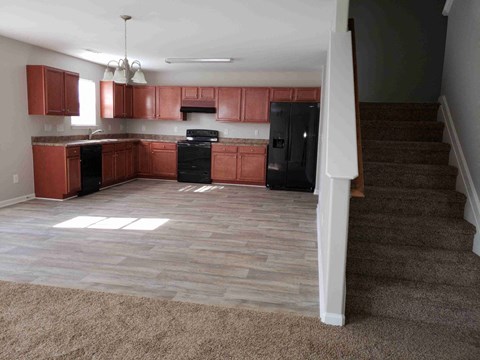 A kitchen with brown cabinets and a black stove top oven.