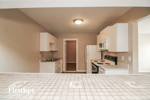 a kitchen with white cabinets and a tiled floor