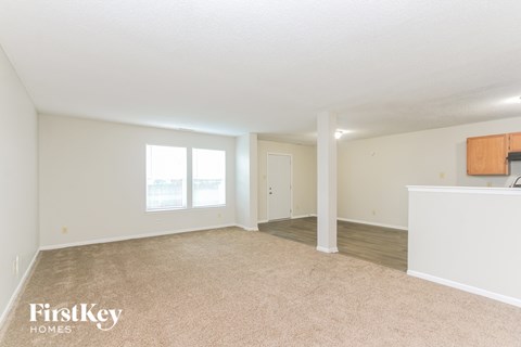 A spacious room with a carpeted floor and a white ceiling.