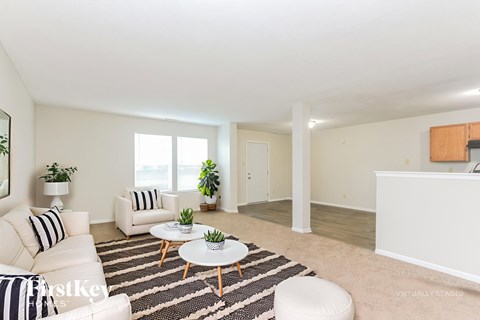 A living room with a white couch, a coffee table, and a rug.