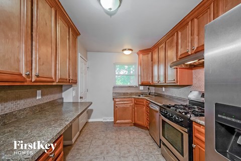 A kitchen with wooden cabinets and a stainless steel stove.