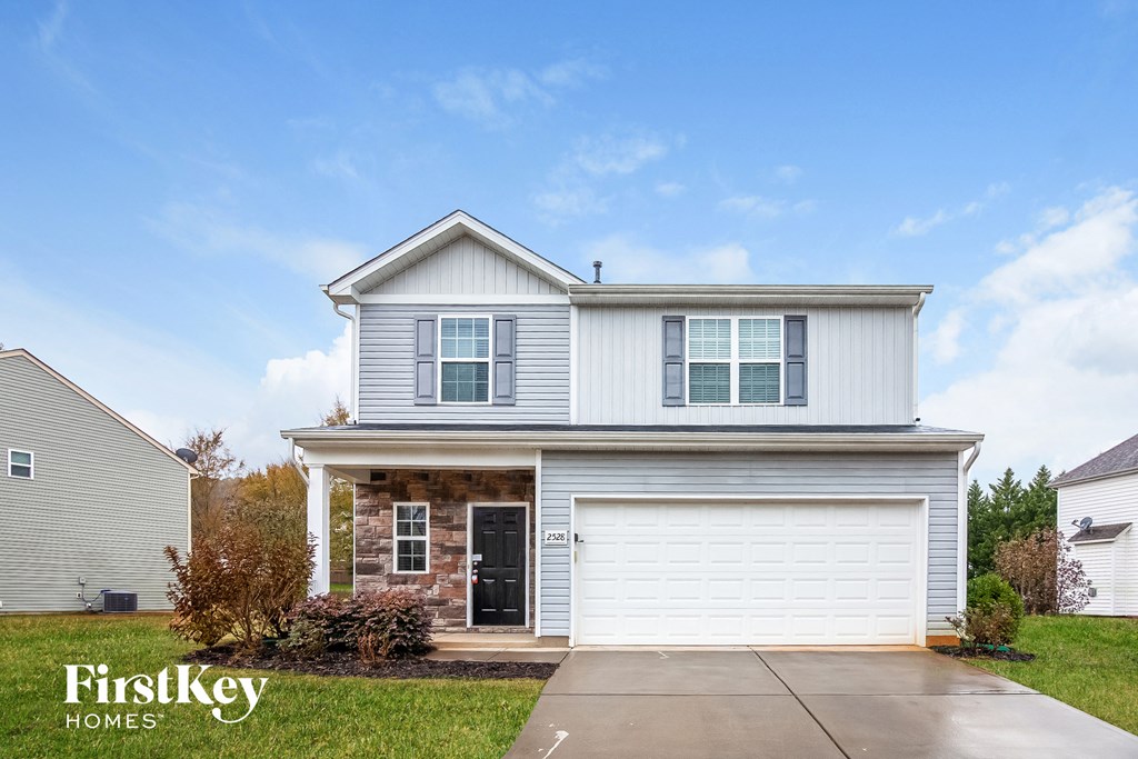 a white house with a garage door and a driveway