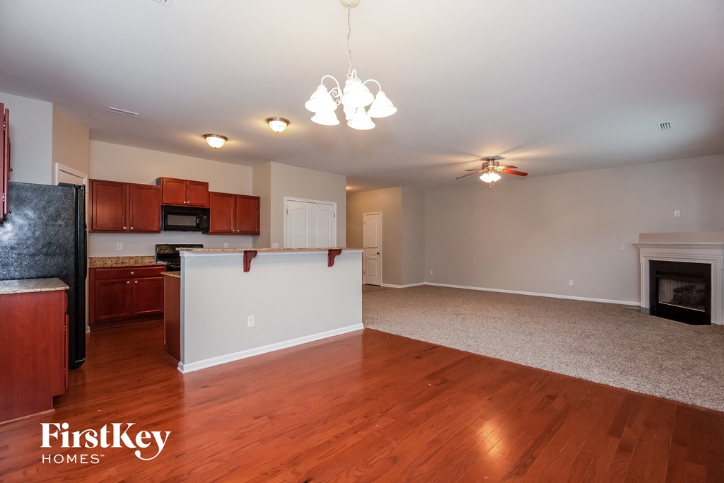 a kitchen and living room with wood flooring and a fireplace