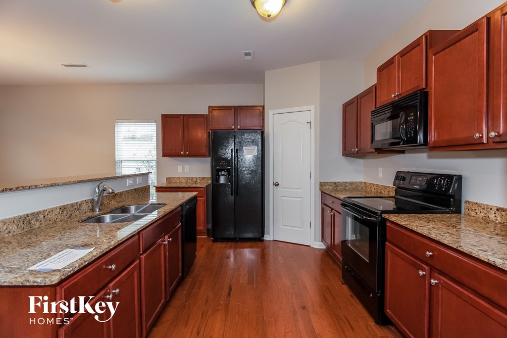 a kitchen with granite counter tops and black appliances