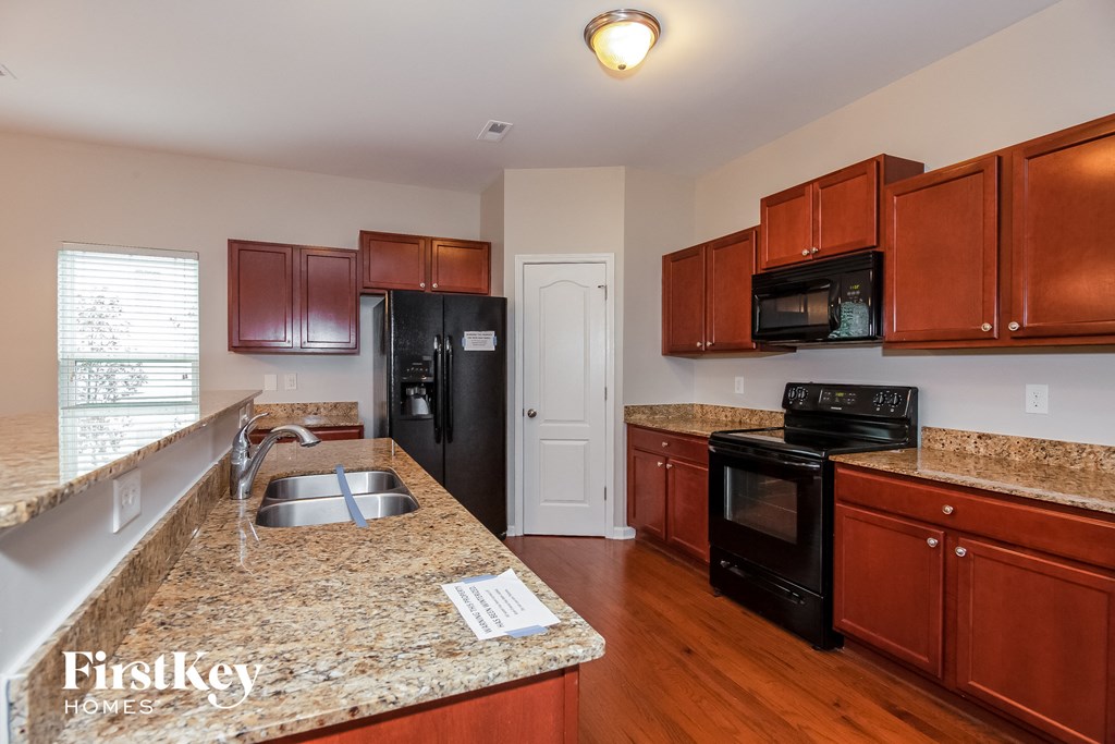 a kitchen with granite counter tops and black appliances