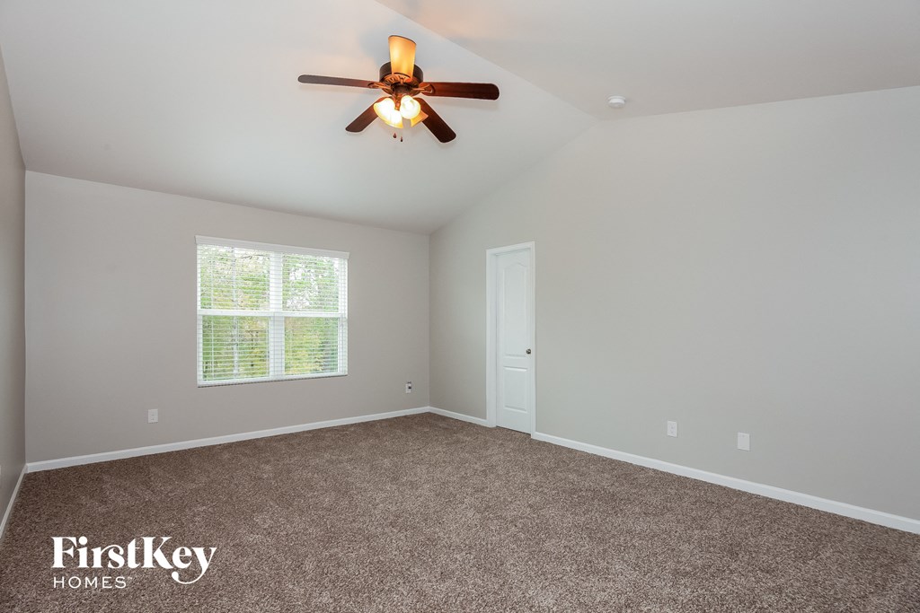 the master bedroom has a carpeted floor and a ceiling fan