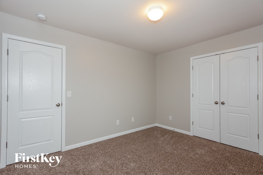 a bedroom with two closets and a carpeted floor