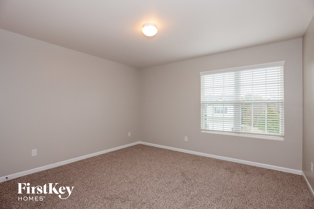 the upstairs bedroom has carpet and a large window