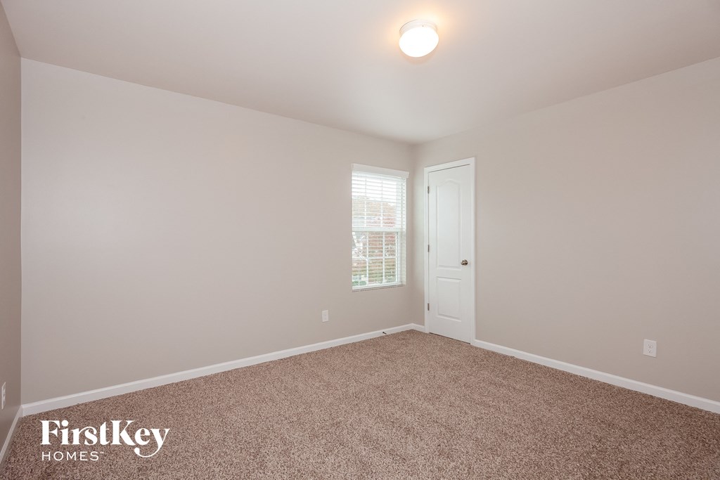 a bedroom with a carpeted floor and a white door