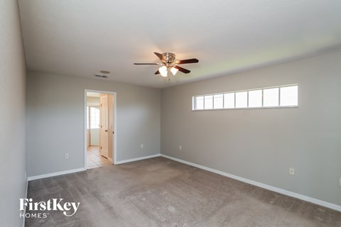 a living room with carpet and a ceiling fan
