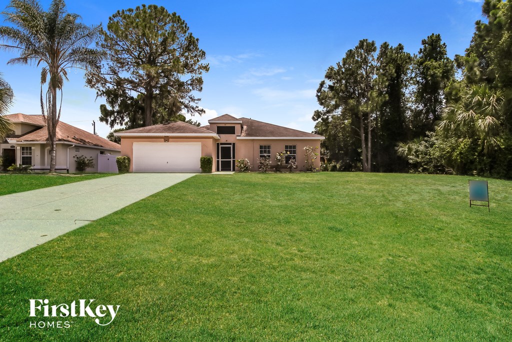 A large, well-maintained lawn in front of a house with a sign that says "FirstKey Homes.".