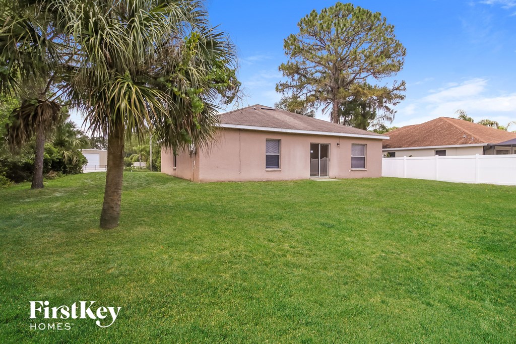 A house with a lawn and trees in front of it.