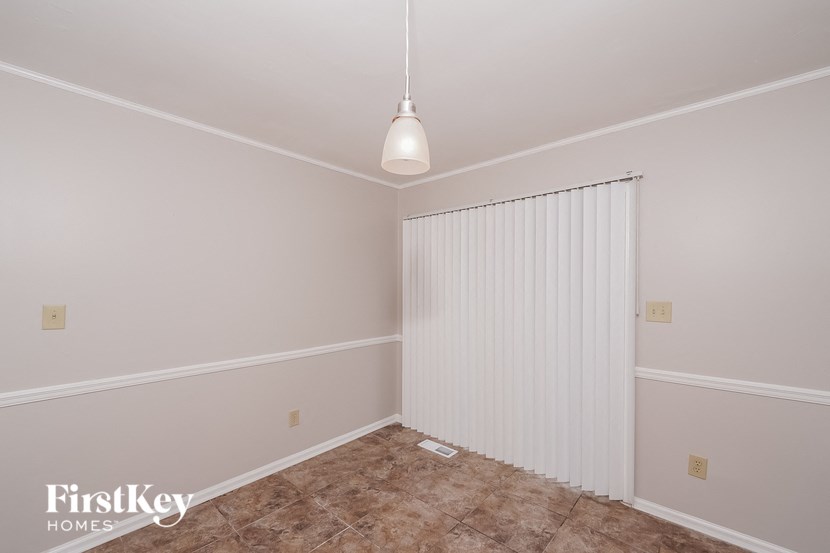 A room with a carpeted floor and a white radiator.