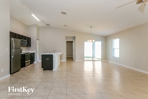 A spacious kitchen with a refrigerator, microwave, and sink.