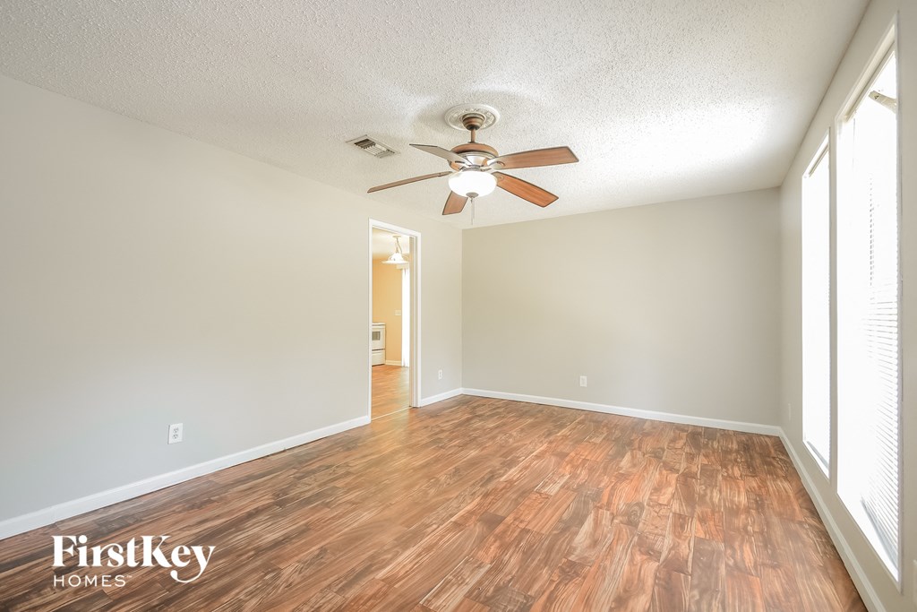 A room with wooden floors and a ceiling fan.