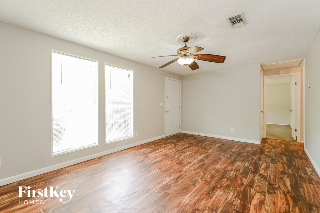 A room with wooden floors and a ceiling fan.