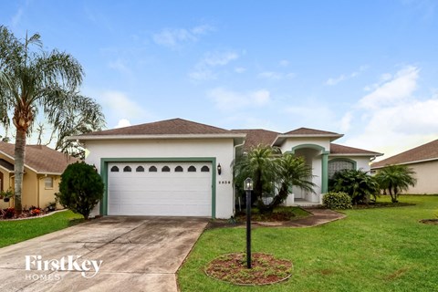a house with a white garage door and palm trees