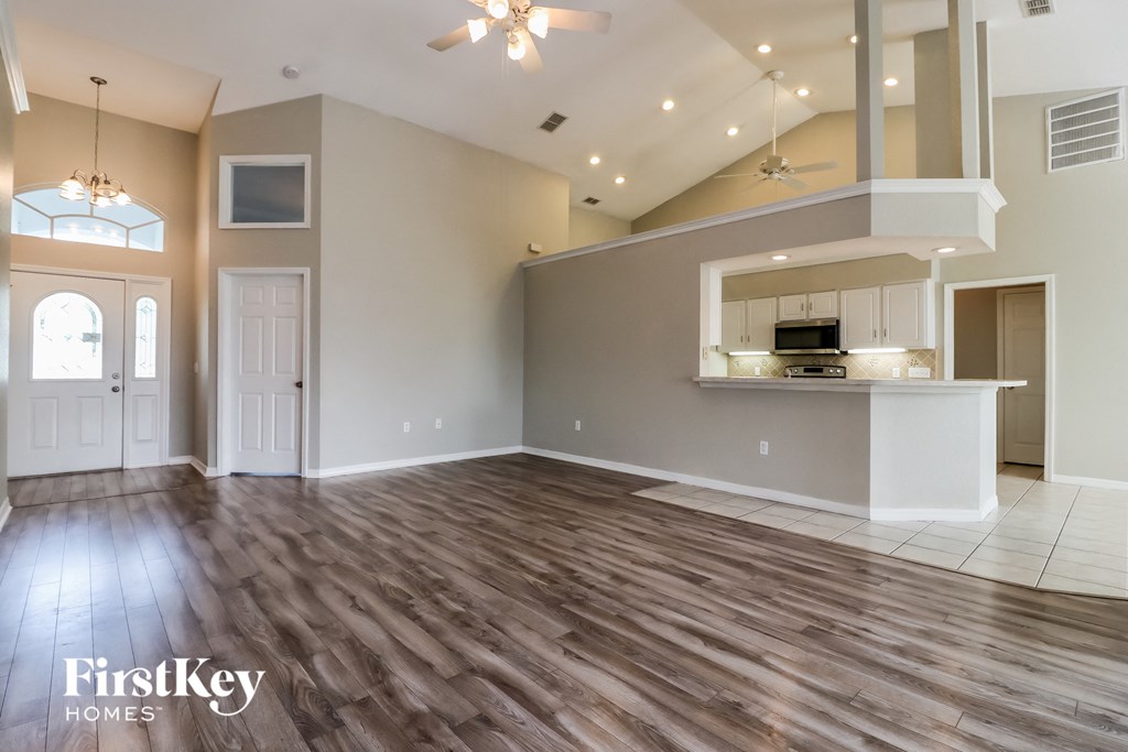 the living room and kitchen of an empty house