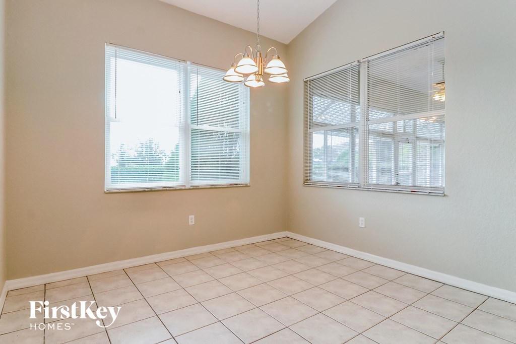 a dining room with two windows and a tiled floor