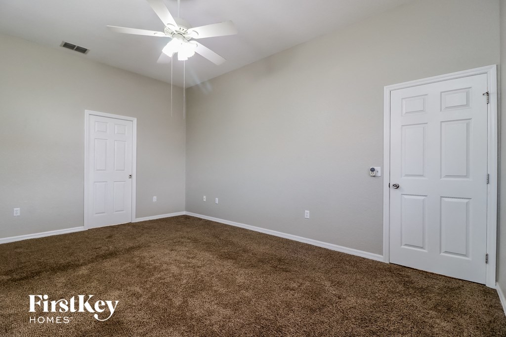 a bedroom with a carpeted floor and white doors