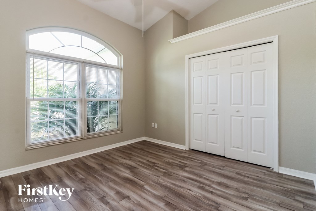 the living room of a home with a large window and a white door