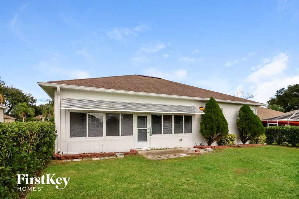 the front of a white house with a yard and grass