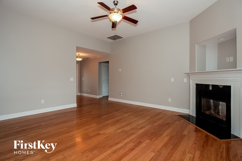 A room with a fireplace and a ceiling fan.