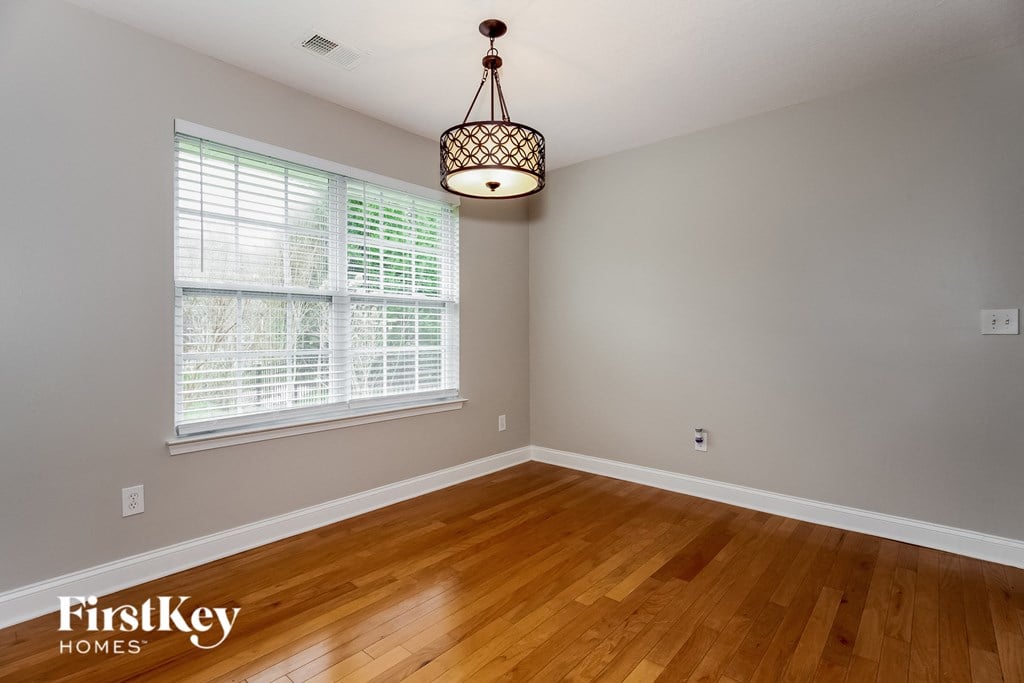 A room with wooden floors and a hanging light fixture.
