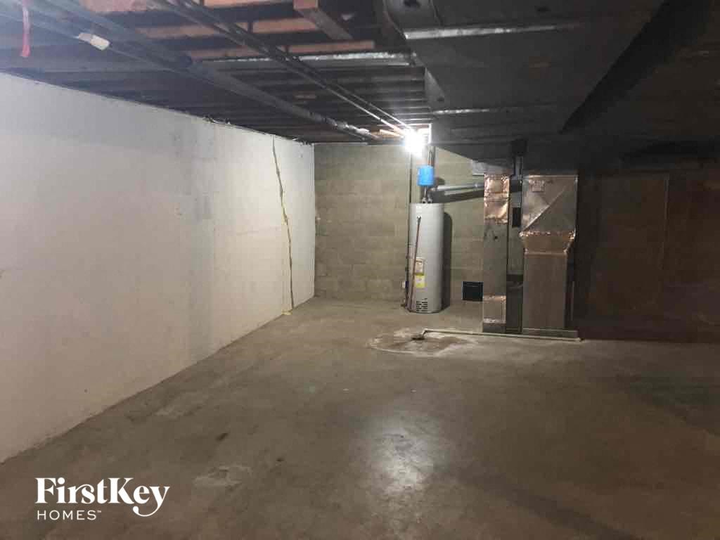 an empty basement with white walls and a concrete floor