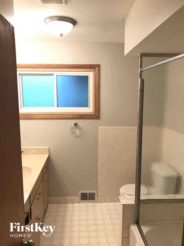 a bathroom with a shower and a sink and a toilet