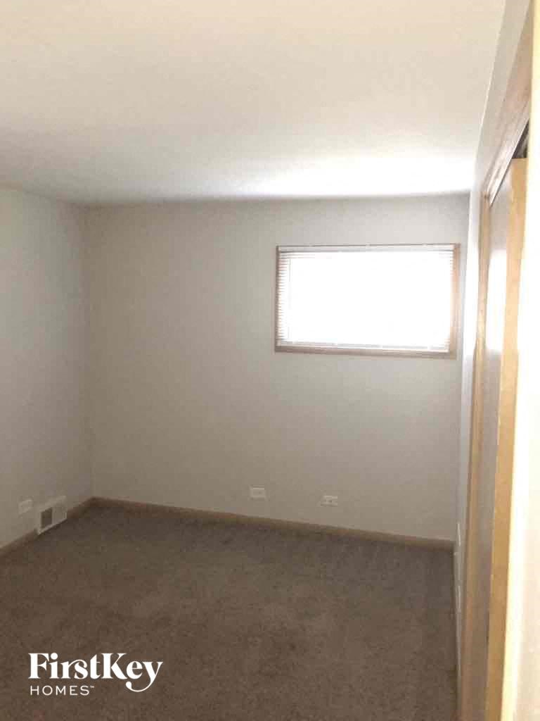 an empty room with a window and a carpeted floor