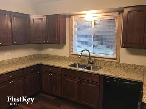 a kitchen with wooden cabinets and a sink and a window