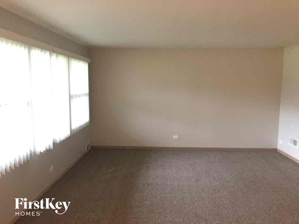 an empty living room with carpet and a large window