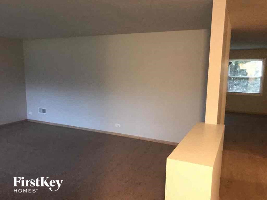 an empty living room in a house with a white wall