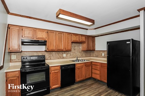 A kitchen with wooden cabinets and black appliances.