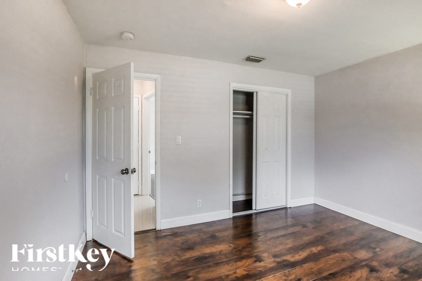 a living room with white walls and wood floors and a white door